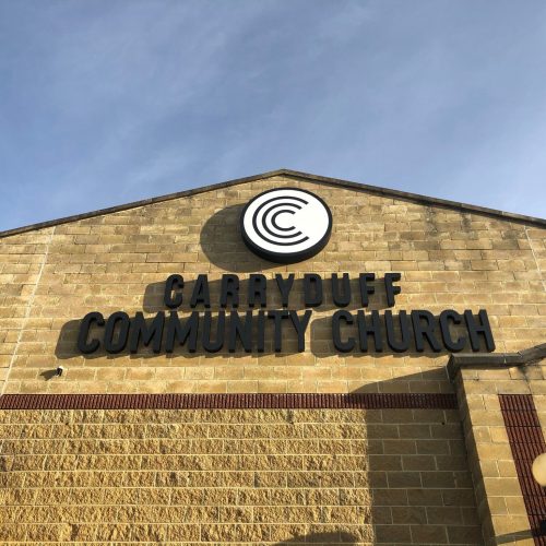 Exterior building signage displayed during daytime using Contra Vision Performance dual colour window film.