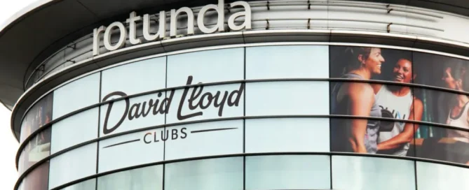 Curved Rotunda building facade featuring David Lloyd Clubs logo and printed fitness graphics on glass.