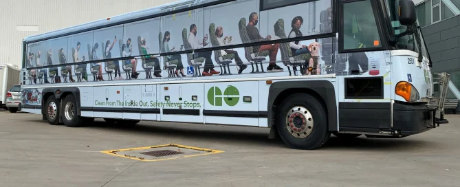 Go Transit bus with Contra Vision window film showing a detailed, realistic graphic of passengers seated inside.