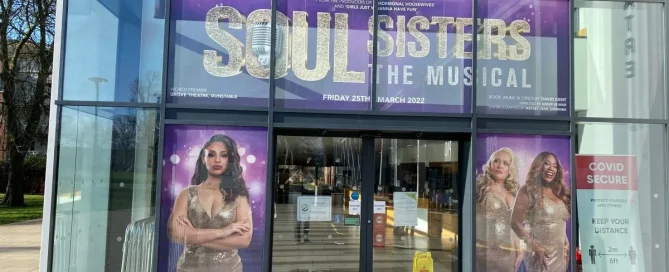Windows at the Grove Theatre featuring promotional Contra Vision window film for theatre shows.