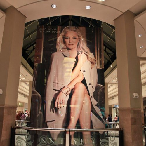 Window graphic of Kate Hudson on a lift using perforated film for one-way visibility.