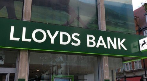 Lloyds Bank branch exterior featuring large green branded window graphics showing a galloping black horse.