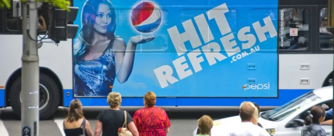 Pepsi branded bus wrap featuring a woman holding a floating soda globe with the text Hit Refresh.