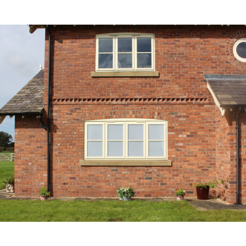 Cream uPVC casement windows on a brick house, featuring frosted privacy film on selected glass panes.