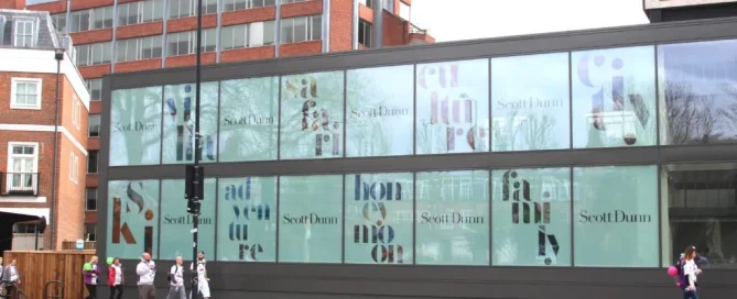 Exterior view of the Scott Dunn travel agency office featuring large window graphics applied to the glass facade.