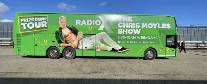 Bright green tour bus covered in a promotional wrap advertisement for The Chris Moyles Radio X Show.