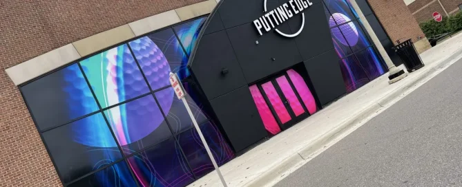 Putting Edge golf centre entrance featuring vibrant, neon-style golf ball graphics on perforated window film.