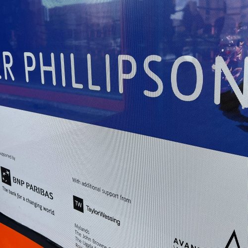 Perforated window vinyl graphic displaying sponsorship logos for BNP Paribas and Taylor Wessing.