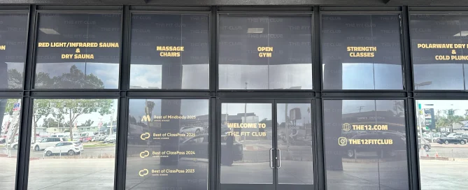 The Fit Club storefront featuring floor-to-ceiling glass windows with elegant gold lettering.